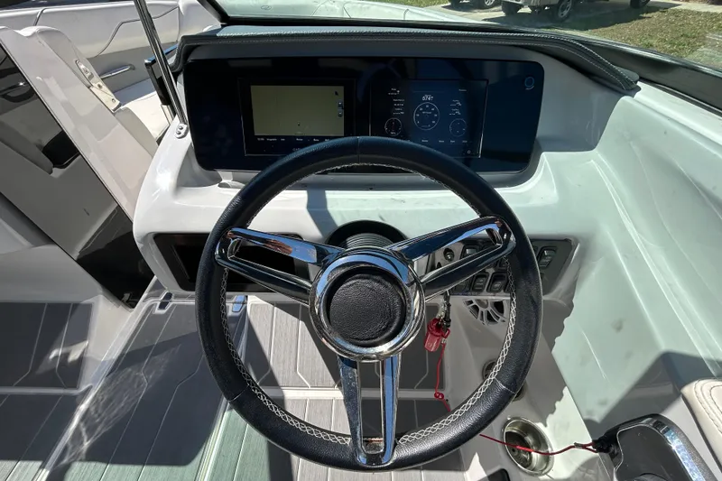Slide: The Image of Steering wheel and dashboard of 2022 Regal LS2 boat, featuring modern controls and display. - 88