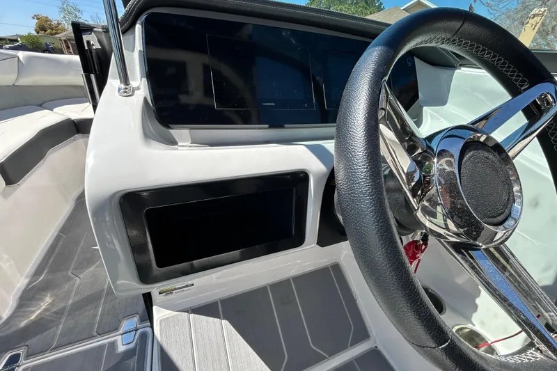 Slide: The Image of 2022 Regal LS2 boat dashboard with steering wheel and digital display. - 89