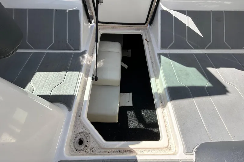 Slide: The Image of 2022 Regal LS2 boat interior storage compartment with open hatch and cushioned seating. - 92