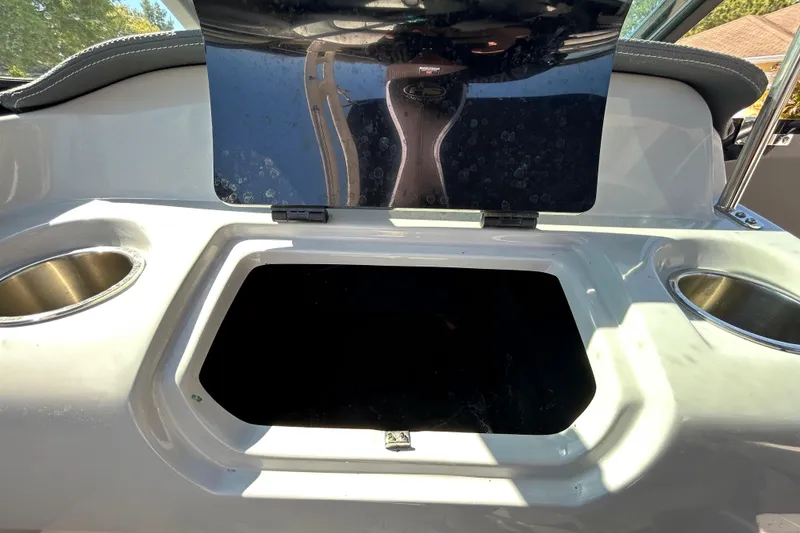 Slide: The Image of 2022 Regal LS2 boat storage compartment with open lid and cup holders. - 95