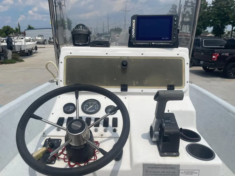 Slide: The Image of Champion 230-RV 2002 boat dashboard with steering wheel, controls, and Lowrance GPS. - 21