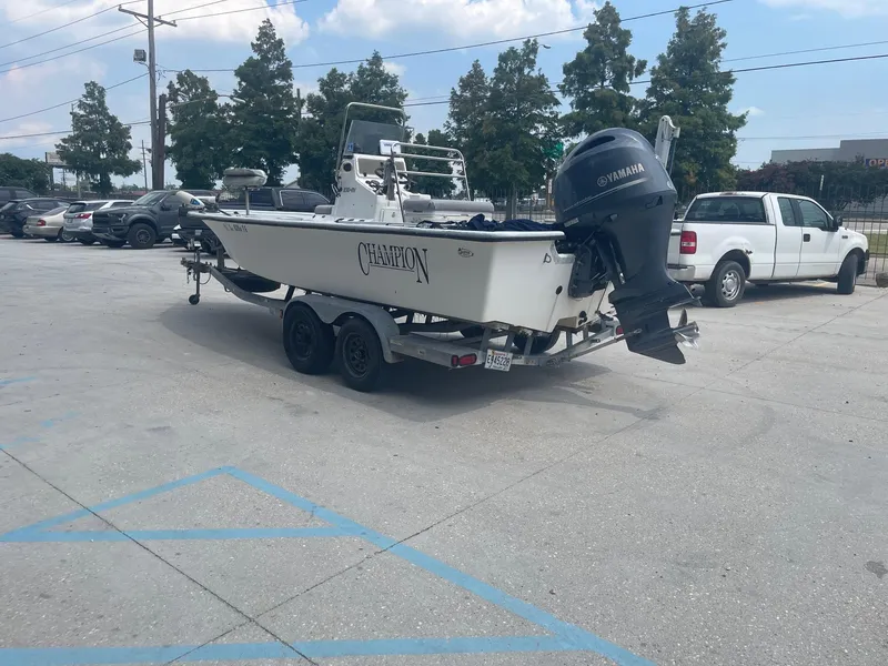 Slide: The Image of 2002 Champion 230-RV boat on trailer in parking lot with Yamaha outboard motor. - 5