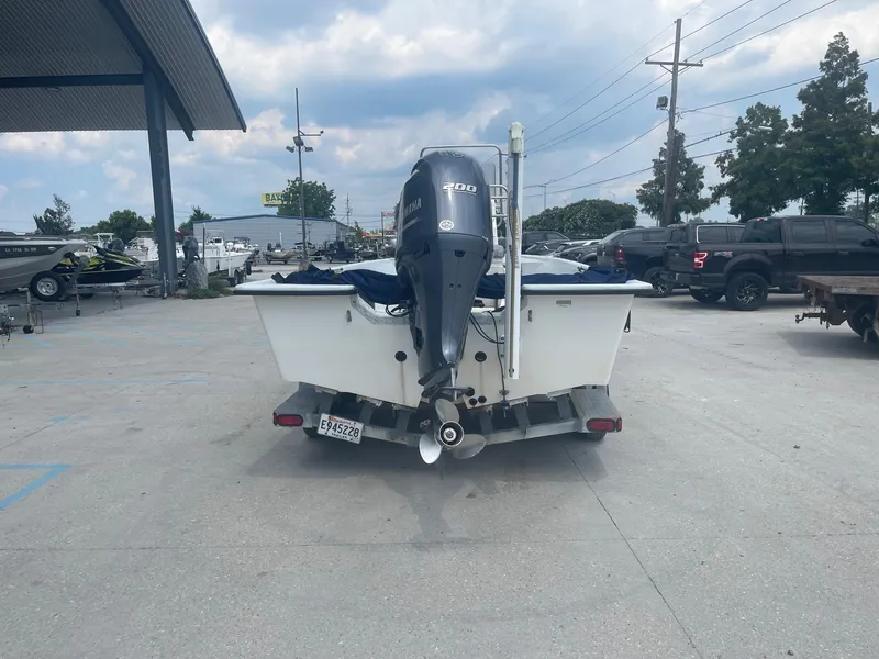 Slide: The Image of Rear view of a 2002 Champion 230-RV boat with an outboard motor in a parking lot. - 6