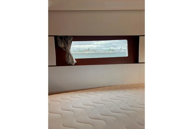 Slide: The Image of Interior view of 2017 Beneteau Oceanis 38.1 cabin with window and mattress. - 29