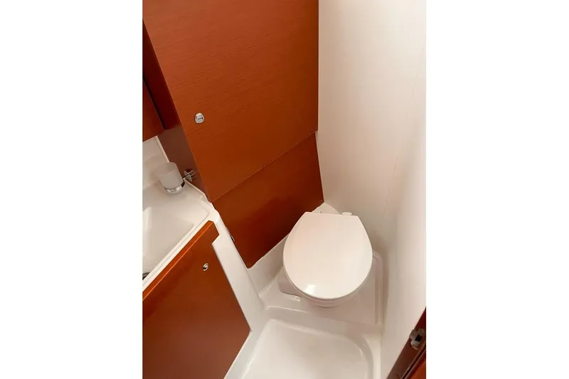 Slide: The Image of 2017 Beneteau Oceanis 38.1 yacht bathroom with wooden cabinetry and compact toilet. - 32
