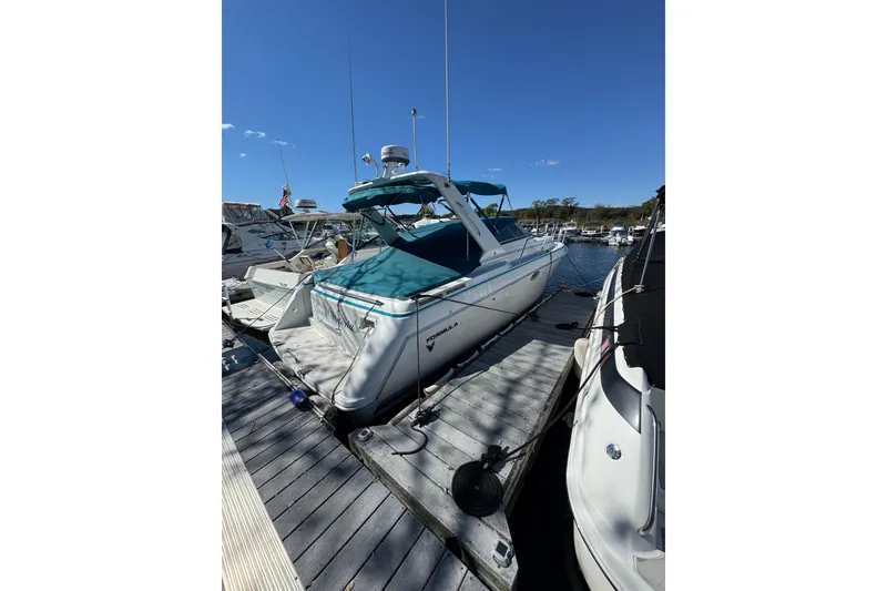 The Image of 1995 Formula 31 Performance Cruiser docked at marina under clear blue sky. - 0