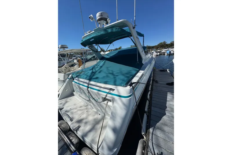 Slide: The Image of 1995 Formula 31 Performance Cruiser docked, featuring teal canopy and sleek design. - 3