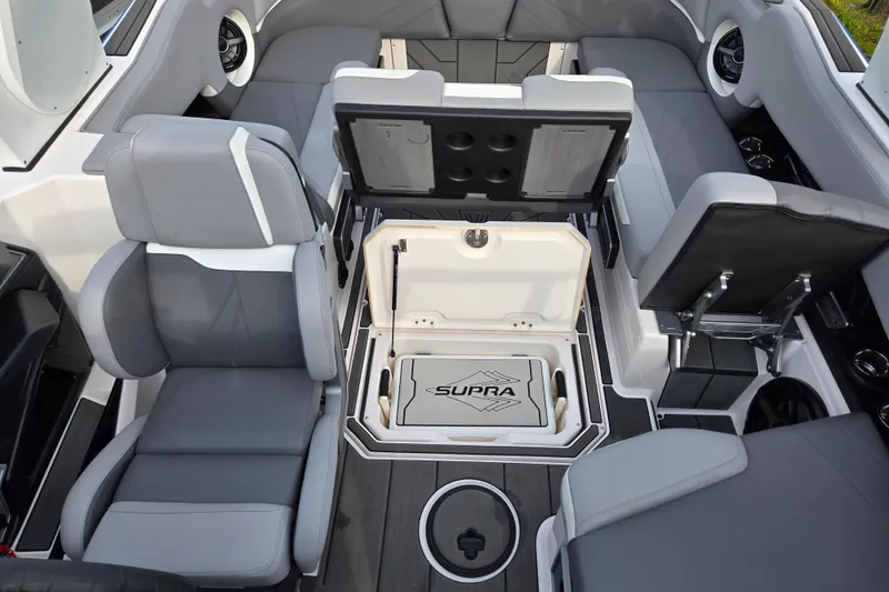 Slide: The Image of 2023 Supra SL 450 boat interior with open storage compartments and gray seating. - 22