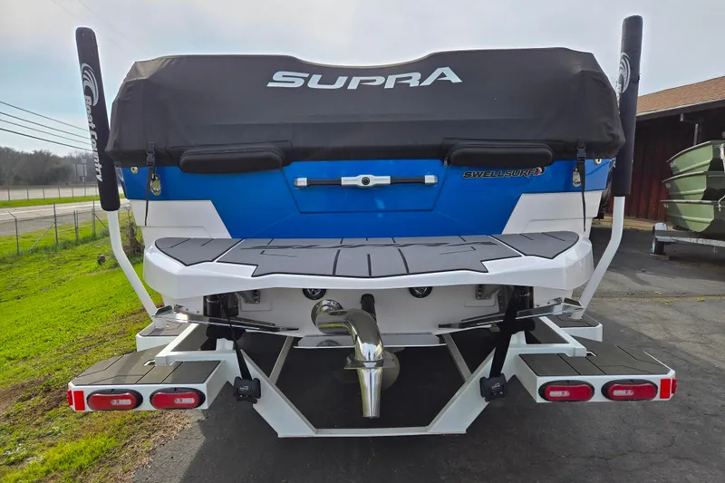 Slide: The Image of 2023 Supra SL 450 boat rear view with SwellSurf system and cover. - 5