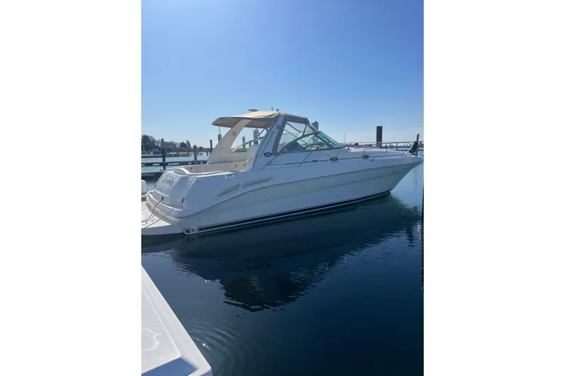 Slide: The Image of 2002 Sea Ray 410 Sundancer yacht docked in a serene marina setting. - 13