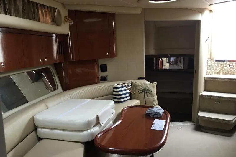 Slide: The Image of Interior of 2002 Sea Ray 410 Sundancer yacht with seating and wooden table. - 6