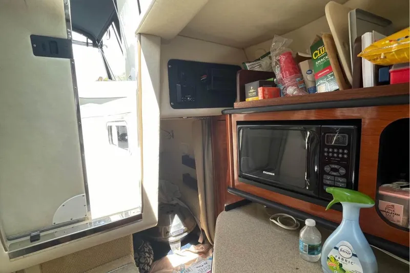 Slide: The Image of Interior of a 2006 Sea Ray Sundancer 260 with microwave and storage shelves. - 11