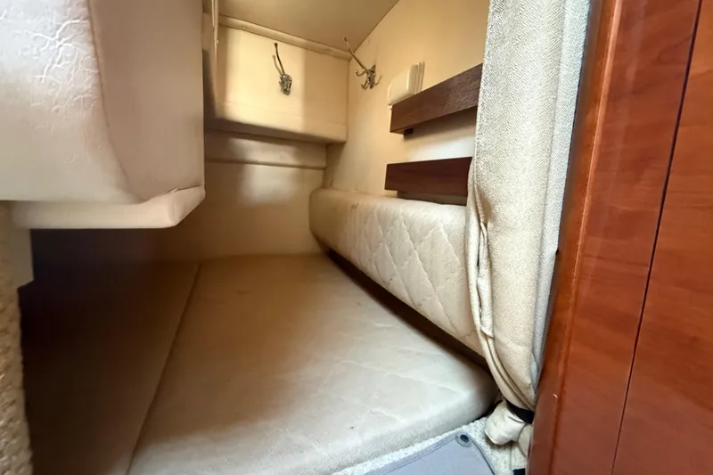 Slide: The Image of 2006 Sea Ray Sundancer 260 cabin interior with beige upholstery and wooden accents. - 18