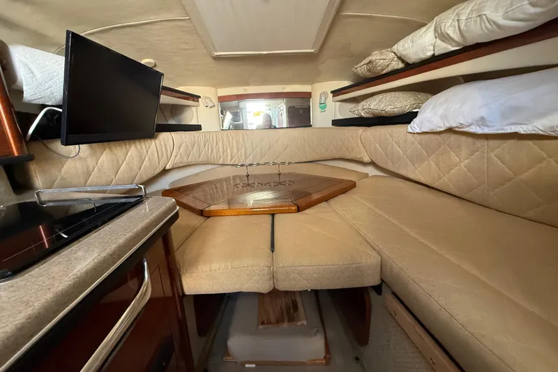 Slide: The Image of Interior of 2006 Sea Ray Sundancer 260 with cozy seating and a small TV. - 19