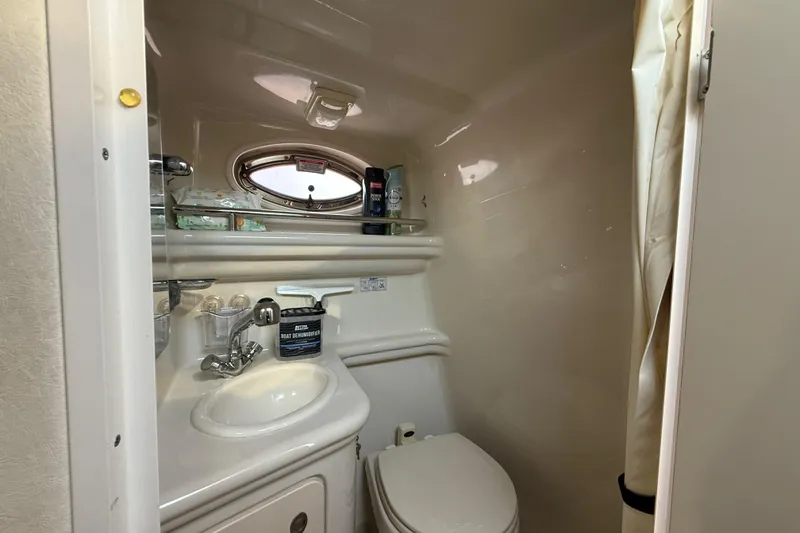 Slide: The Image of 2006 Sea Ray Sundancer 260 bathroom with sink, toilet, and porthole window. - 20