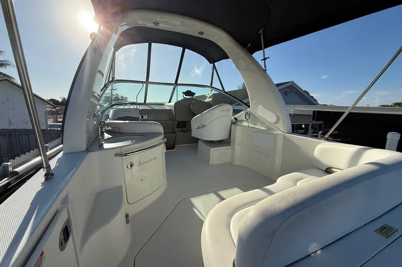 Slide: The Image of 2006 Sea Ray Sundancer 260 boat interior with helm, seating, and sunlit canopy. - 22