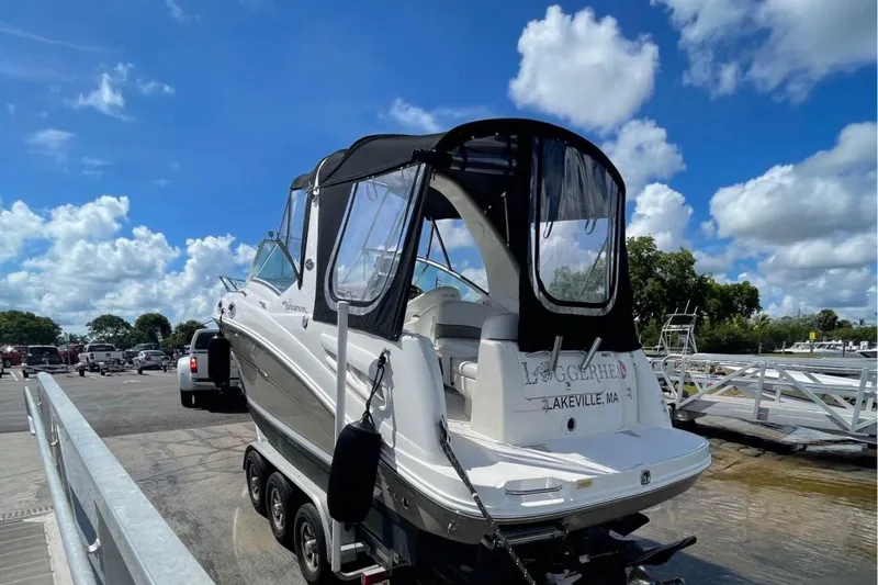 Slide: The Image of 2006 Sea Ray Sundancer 260 boat on trailer at dock under blue sky. - 29
