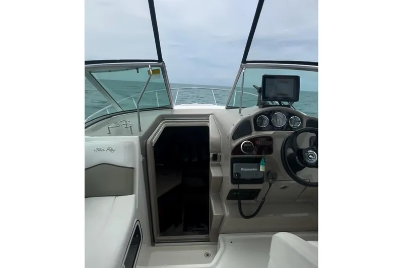 Slide: The Image of 2006 Sea Ray Sundancer 260 cockpit with steering wheel and navigation equipment, ocean view. - 6