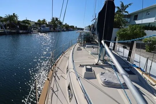 Slide: The Image of Interior of 1989 Island Packet 38 sailboat with white seating and wooden accents. - 12