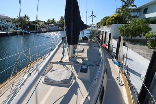 Slide: The Image of 1989 Island Packet 38 sailboat cabin with cozy blue cushions and wooden cabinetry. - 13