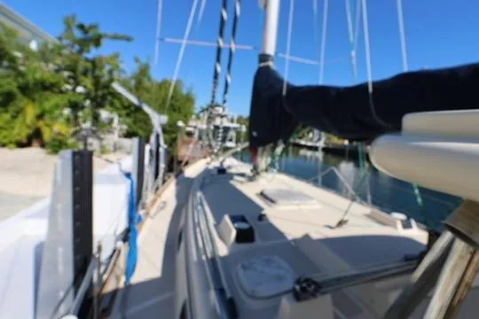 Slide: The Image of 1989 Island Packet 38 sailboat cockpit with marina view, featuring covered equipment and seating. - 18