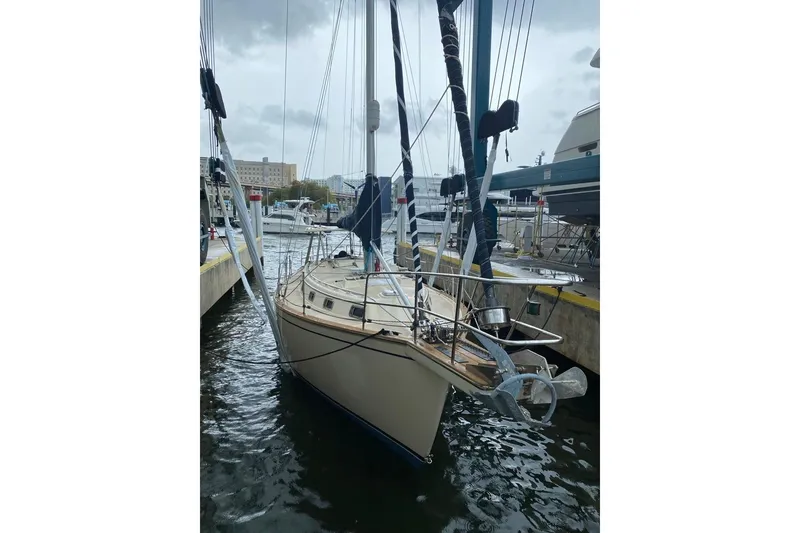 Slide: The Image of 1989 Island Packet 38 sailboat cockpit with wooden hatch, docked by a canal. - 2