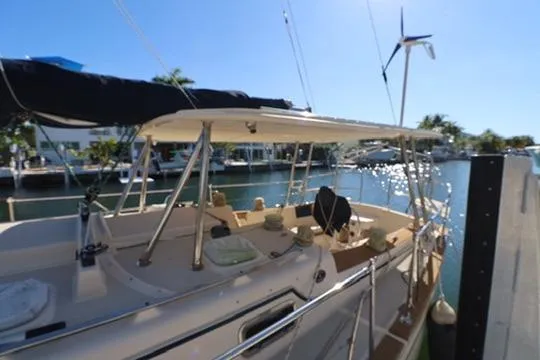 Slide: The Image of 1989 Island Packet 38 sailboat cockpit with steering wheel, docked by a canal. - 20