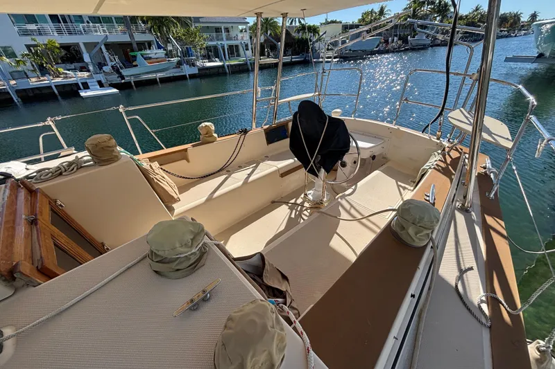Slide: The Image of Interior of 1989 Island Packet 38 sailboat with white cushioned seating. - 7
