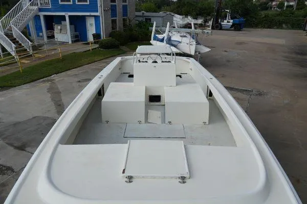 Slide: The Image of 1978 Bertram 31 Sportfisher boat on land, showcasing spacious deck and storage compartments. - 2