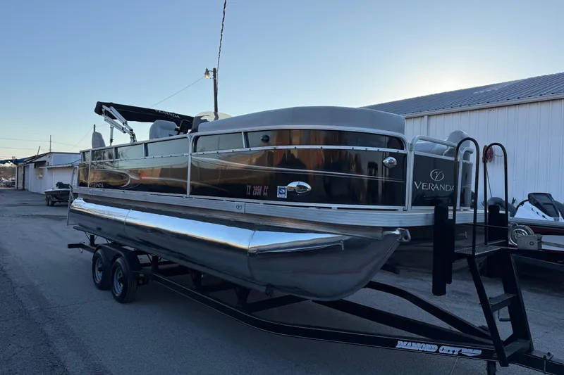Slide: The Image of 2014 Veranda Fishing V2075-F2 pontoon boat on trailer, parked near a building. - 24