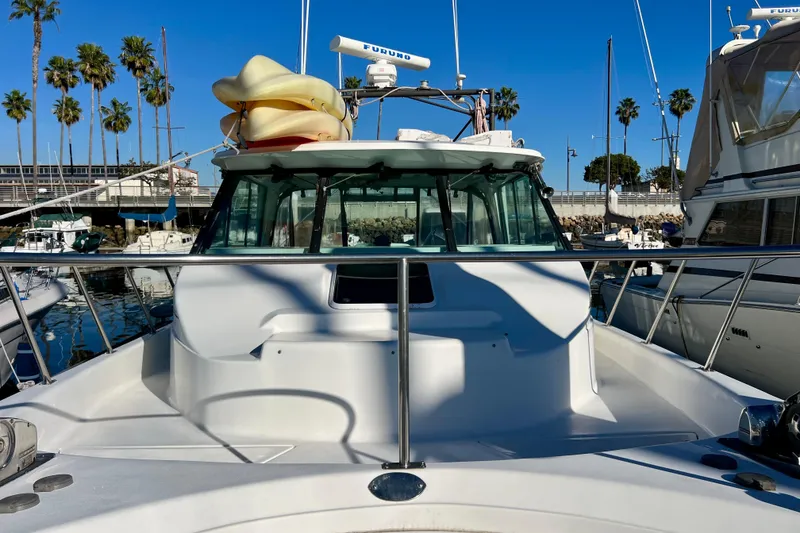 Slide: The Image of 1998 Baha Cruisers 340 CAT docked at marina, clear sky, palm trees in background. - 15