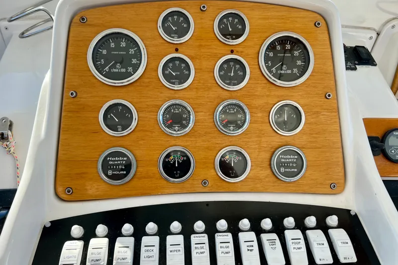 Slide: The Image of 1998 Baha Cruisers 340 CAT dashboard with gauges and switches on wooden panel. - 36