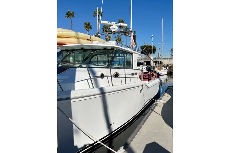 Slide: The Image of 1998 Baha Cruisers 340 CAT docked, featuring sleek design and sunny marina backdrop. - 4