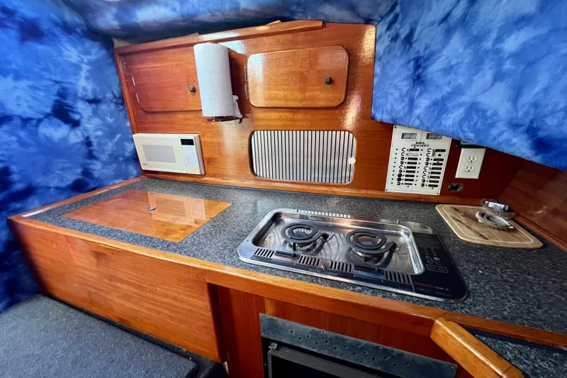 Slide: The Image of 1998 Baha Cruisers 340 CAT boat kitchen with stove, microwave, and wooden cabinetry. - 41