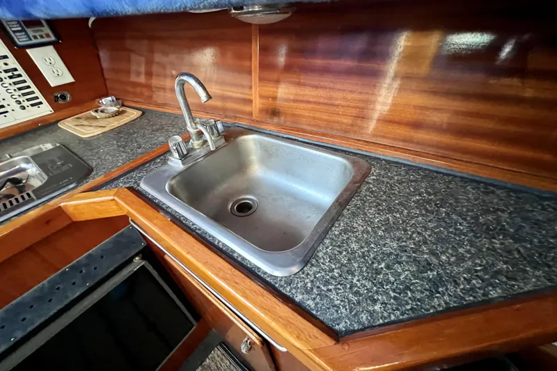 Slide: The Image of 1998 Baha Cruisers 340 CAT boat kitchen with sink and wooden cabinetry. - 42