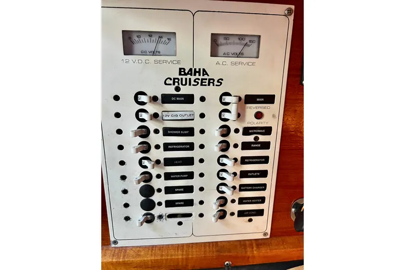 Slide: The Image of Control panel of a 1998 Baha Cruisers 340 CAT boat, featuring various switches and gauges. - 44