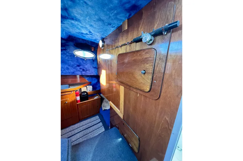 Slide: The Image of 1998 Baha Cruisers 340 CAT cabin interior with wood paneling and fishing rod. - 46