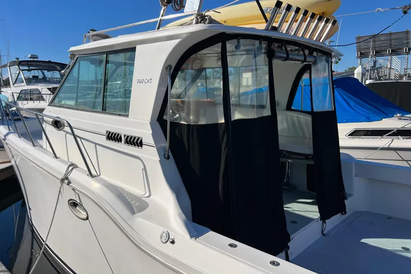 Slide: The Image of 1998 Baha Cruisers 340 CAT boat docked, featuring sleek design and spacious cabin. - 5