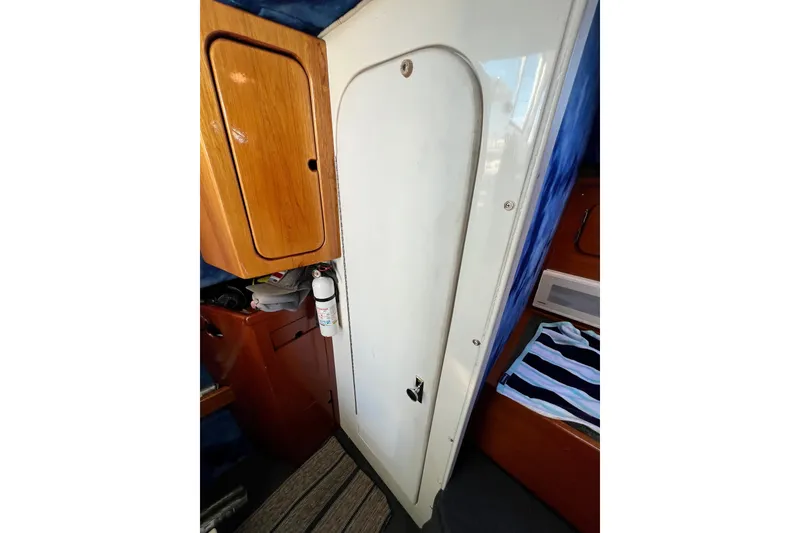 Slide: The Image of Interior of 1998 Baha Cruisers 340 CAT with wooden cabinet and white door. - 51