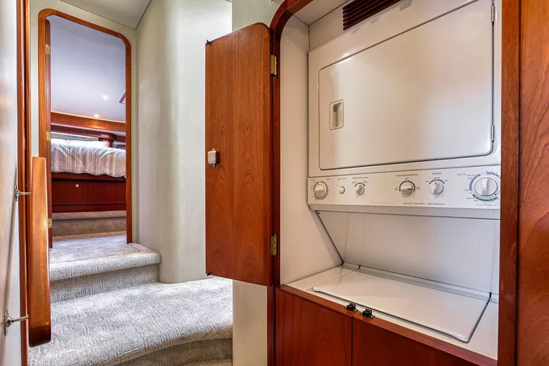 Slide: The Image of Laundry area in 2004 West Bay SonShip 72 Motoryacht, featuring a compact washer-dryer unit. - 17