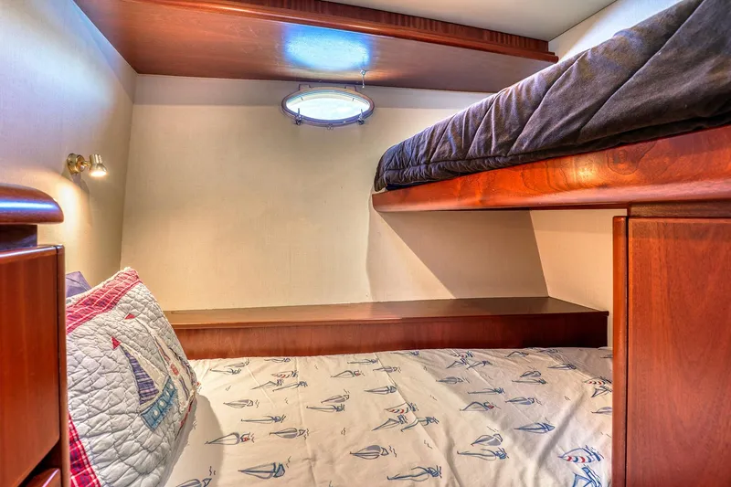 Slide: The Image of Cozy bunk bed cabin in 2004 West Bay SonShip 72 Motoryacht, featuring nautical-themed bedding. - 23