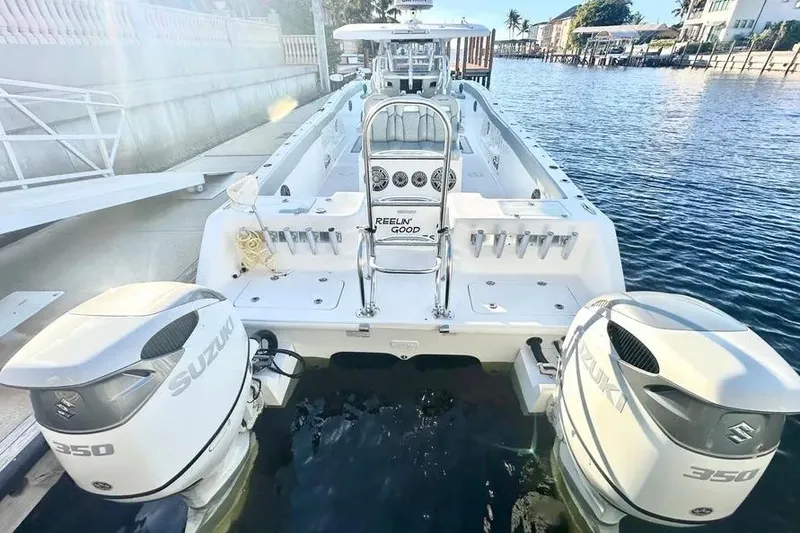 Slide: The Image of 2023 Twin Vee 340 GFX CC boat with dual Suzuki 350 engines docked by the water. - 3