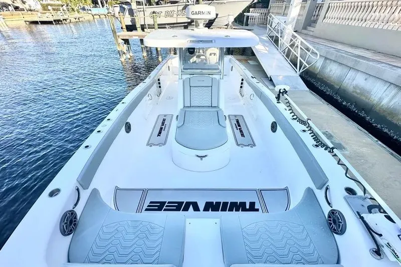Slide: The Image of 2023 Twin Vee 340 GFX CC boat docked, showcasing spacious deck and modern design. - 6