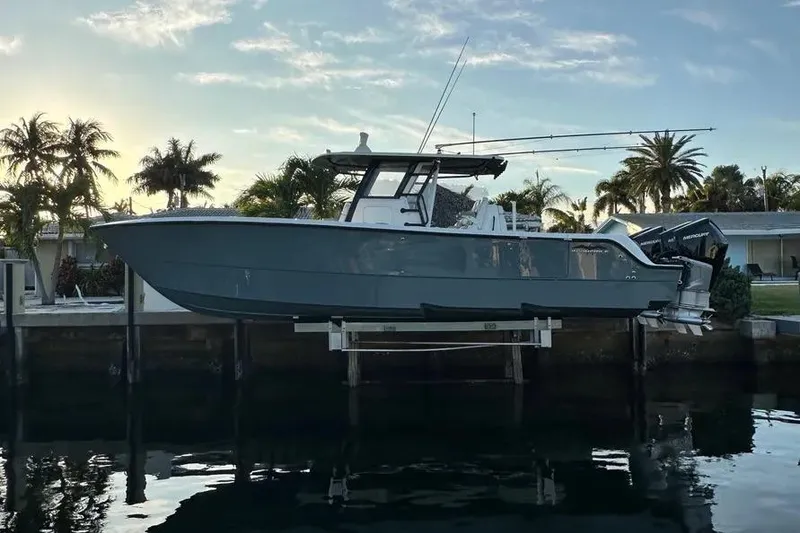 The Image of 2022 Invincible 35 Catamaran docked, with palm trees and sunset in the background. - 0