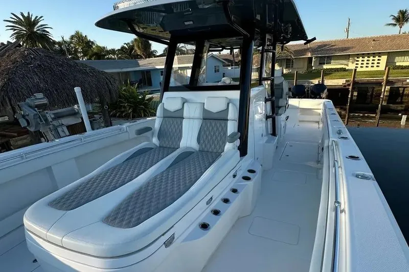 Slide: The Image of 2022 Invincible 35 Catamaran with luxurious seating, docked near waterfront homes. - 18