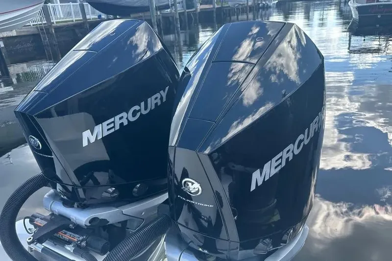 Slide: The Image of Twin Mercury outboard engines on a 2022 Invincible 35 Catamaran, reflecting sky and water. - 34