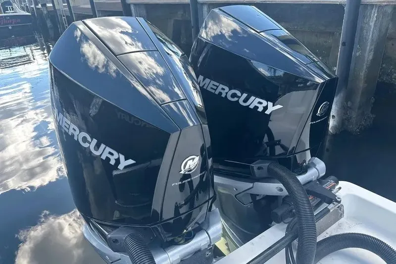 Slide: The Image of Twin Mercury outboard engines on a 2022 Invincible 35 Catamaran, reflecting sky and water. - 35