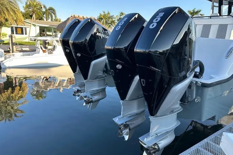 Slide: The Image of 2022 Invincible 35 Catamaran with triple Mercury 300 engines docked by palm trees. - 36