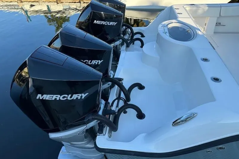 Slide: The Image of Triple Mercury engines on 2022 Invincible 35 Catamaran, docked by the water. - 37