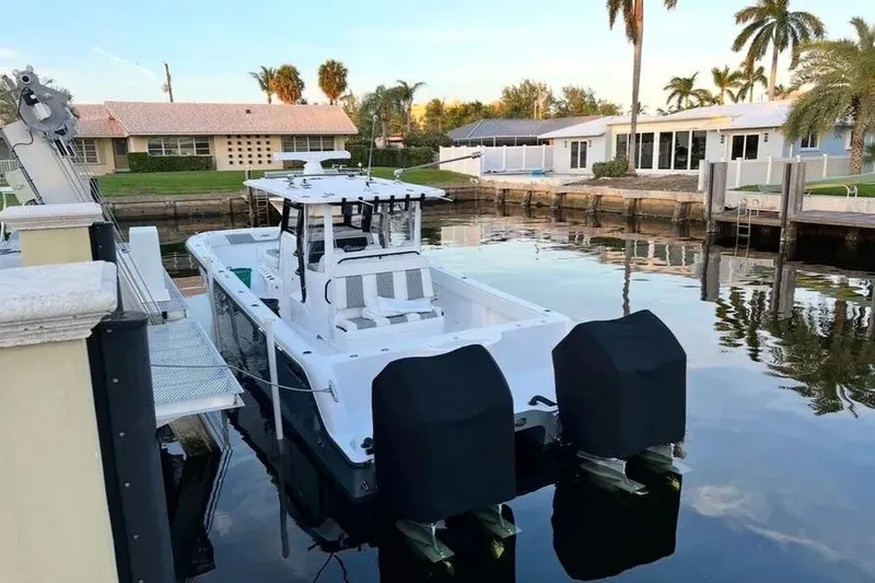 Slide: The Image of 2022 Invincible 35 Catamaran docked in a serene residential canal setting. - 8